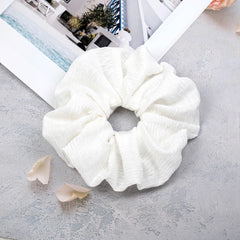 JGQUR scrunchie next to a coin for size scale and fit reference