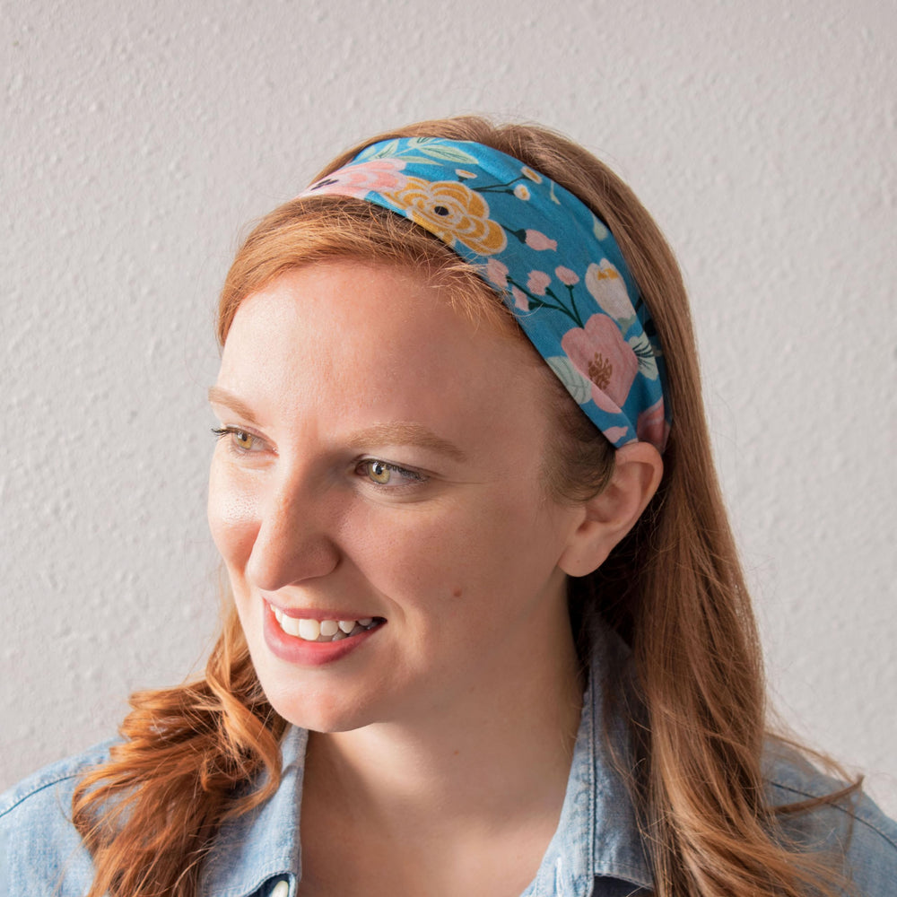 Karma headband held in hand for scale showing compact, travel-friendly size