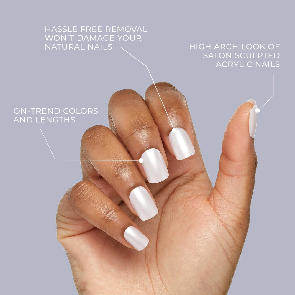 Hand applying KISS nail with glue demonstrating simple press-on application