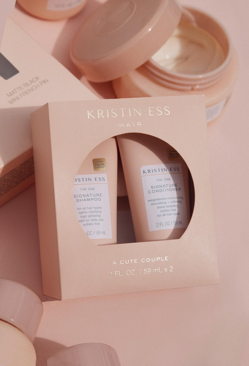 Kristin Ess conditioner pouring from bottle highlighting smoothing hydration