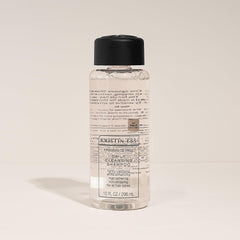 Kristin Ess bottle beside a ruler showing 10 fl oz size