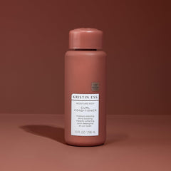 Kristin Ess bottle held in hand showing 10 fl oz scale