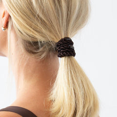L. Erickson hair tie held in hand for scale showing comfortable size