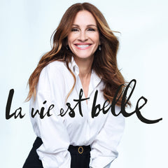 Lancôme applied to wrist in lifestyle setting showing layering with perfume benefit: enhanced scent