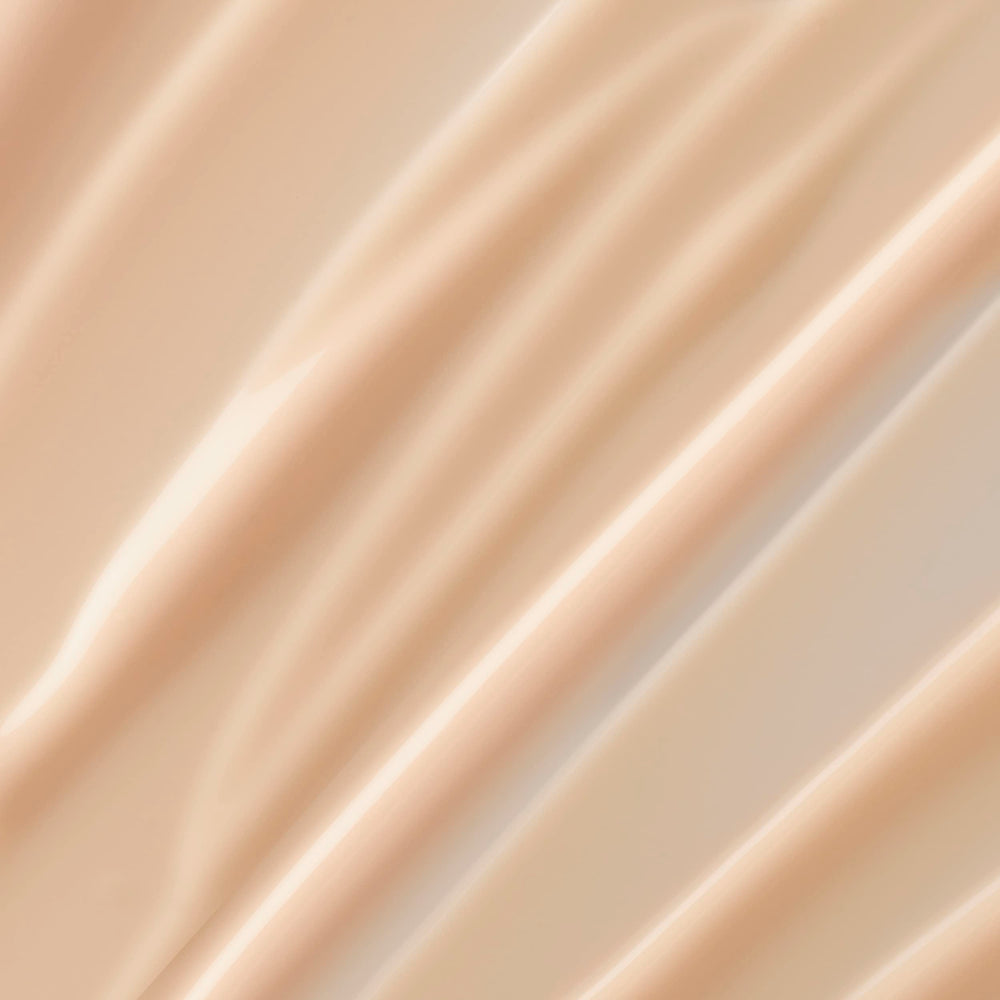 Lancôme Trésor lotion close-up of pump dispensing cream, quick-absorbing texture for silky skin