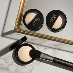 LAURA GELLER NEW YORK compact beside coin for scale to show size portability