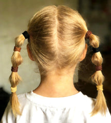 Lintopos lifestyle shot of child playing with ponytail demonstrating durability