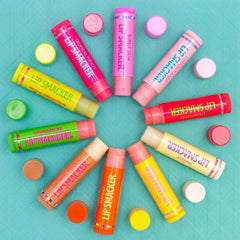 Hand holding Lip Smacker tubes for size scale, highlighting portability and sharing