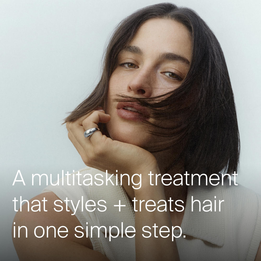 Living Proof applying treatment to damp hair for even distribution and protection