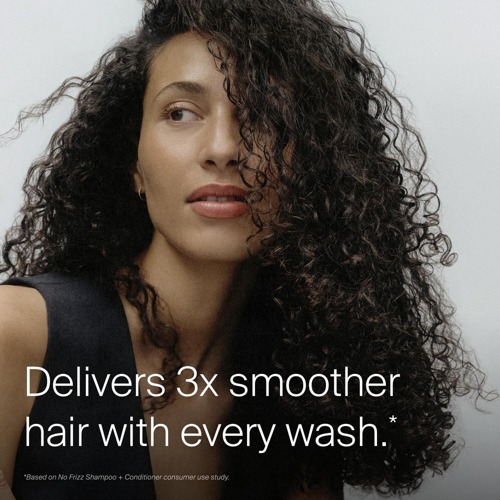 Living Proof shampoo in hand rinsing hair for visible frizz reduction
