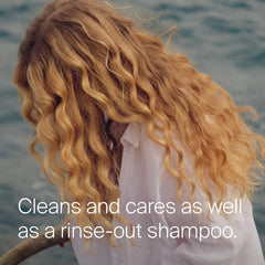 Living Proof spritzing on roots to remove oil and refresh hair benefit