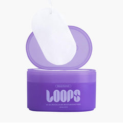 LOOPS pad in hand demonstrating hygienic single-use application and travel-friendly design