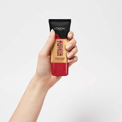 L'Oreal Paris bottle in hand showing 1 fl oz scale and travel-friendly size
