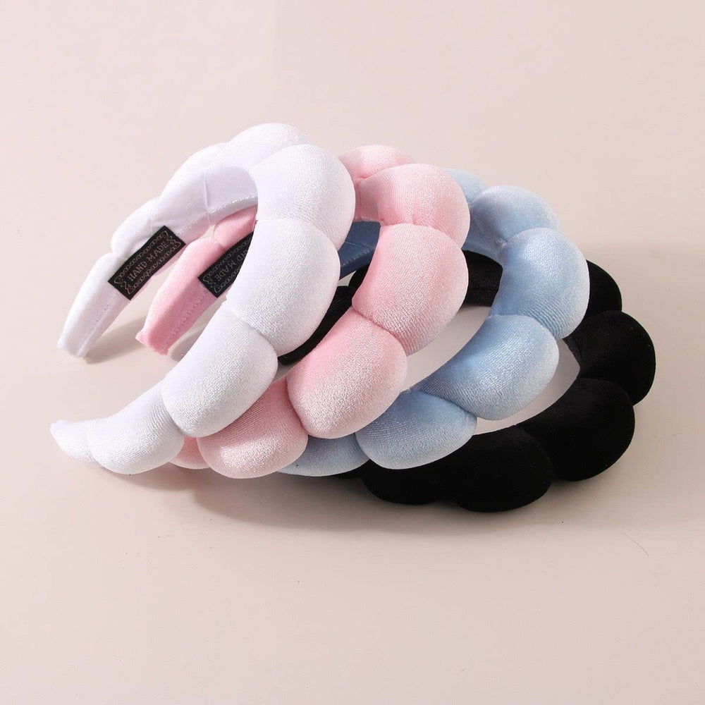 Luckybear headband next to hand showing size and stretch fit
