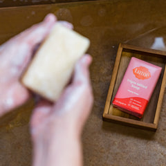 Lume Peony Rose bar in hand illustrating size and easy grip for everyday use