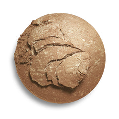 Makeup Revolution bronzer swatch with brush showing buildable shimmer benefit