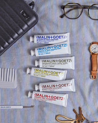 MALIN+GOETZ flatlay of natural ingredient components illustrating clean, vegan formulas