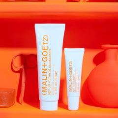 MALIN+GOETZ in a beach bag scene illustrating reef-safe protection for outdoor days