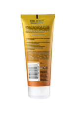 Marc Anthony cream texture closeup on fingers, shows smooth coconut-enriched formula for soft waves
