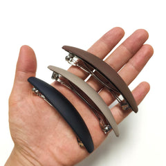 Markuii barrette held in hand to show 4-inch scale and easy handling