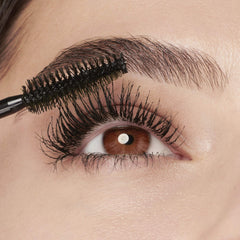 MAYBELLINE mascara tube beside coin showing compact size and travel convenience