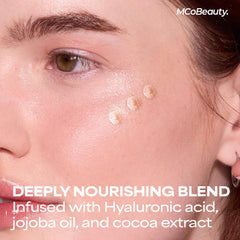 MCoBeauty model applying drops to cheekbone for natural radiance