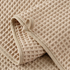 MICROFI towel held in hand showing 12x12 scale and travel-friendly convenience