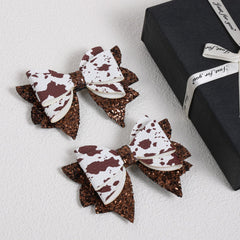 Miroksh close-up of glitter fabric texture on cow print bow highlighting shimmering finish and durability