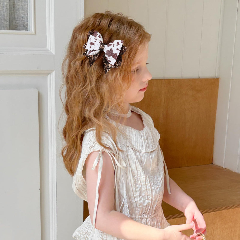 Miroksh bow held in an adult hand to show true 3.5-inch scale for styling decisions