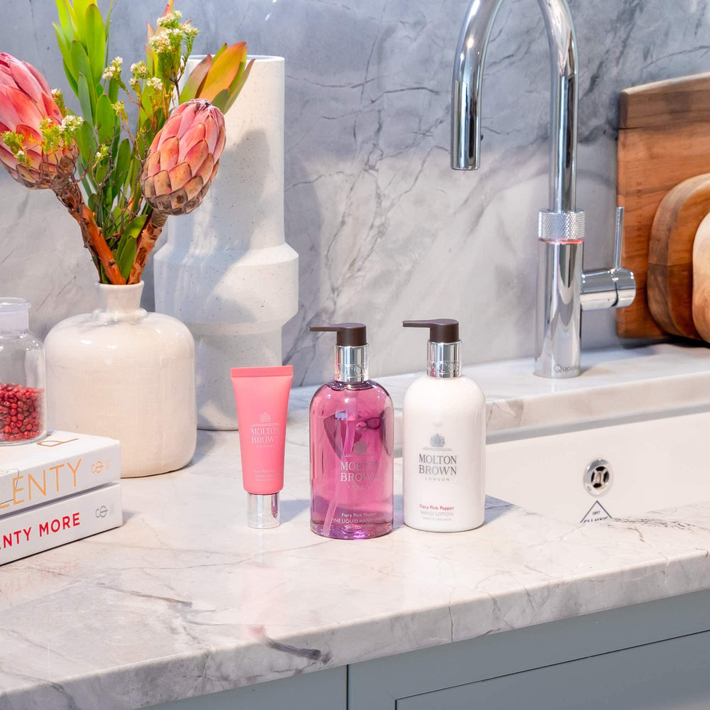 Molton Brown bottle in hand for scale demonstrating a 10 fl. oz. size ideal for sinks