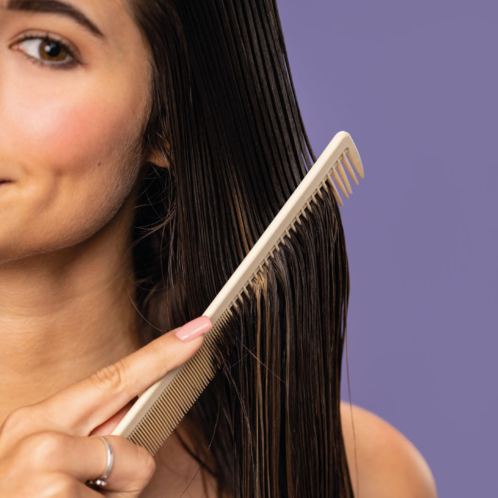 MONAT bottle next to hairbrush showing product size and styling benefit