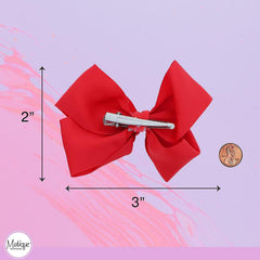 Motique Accessories bow beside ruler showing 3-inch size for scale