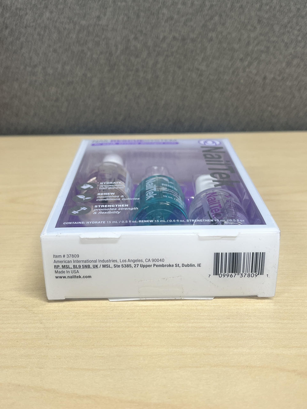 side-by-side with a coin showing Nail Tek 0.5 oz compact travel-friendly size