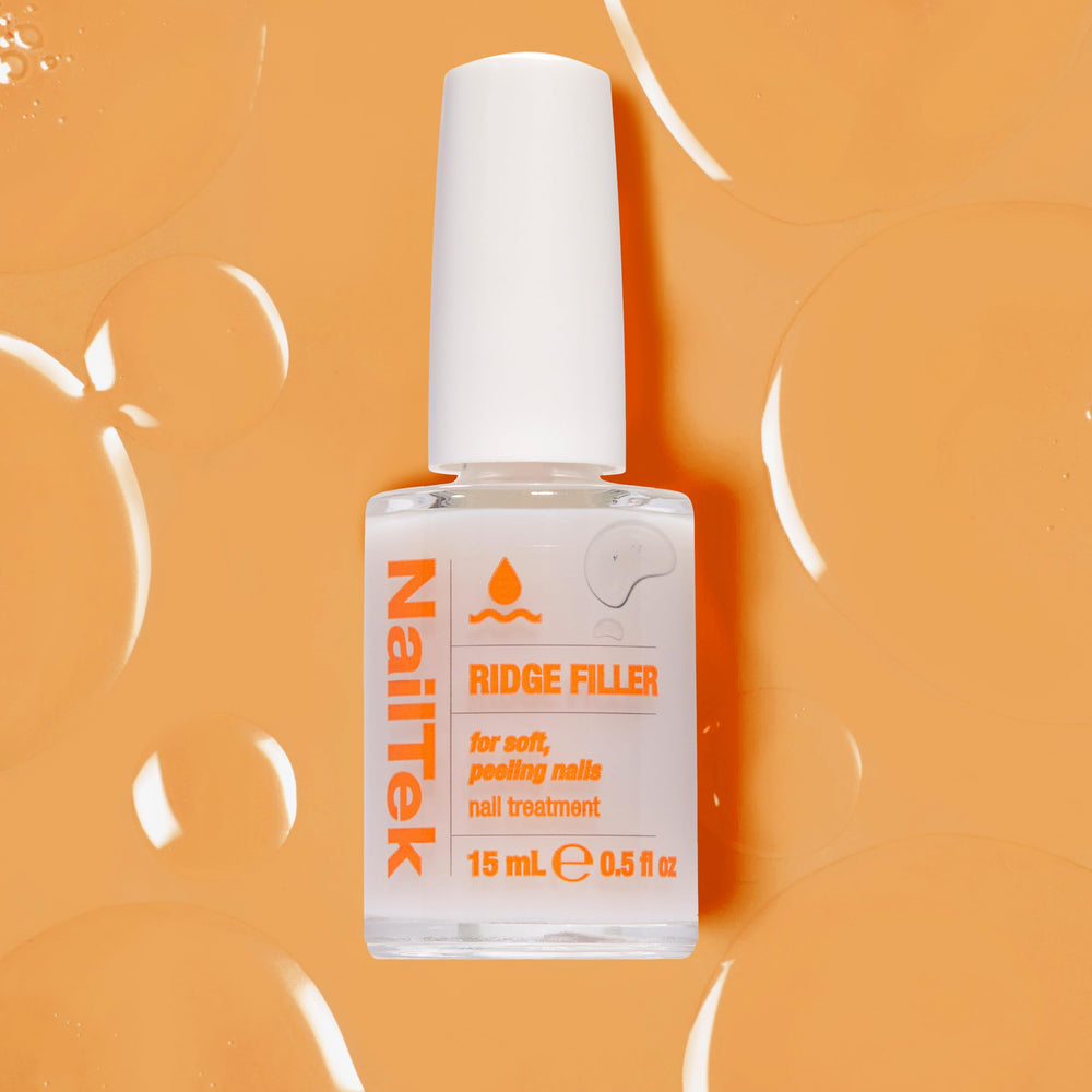 Nail Tek next to a ruler for size scale showing compact 0.5 fl oz convenience
