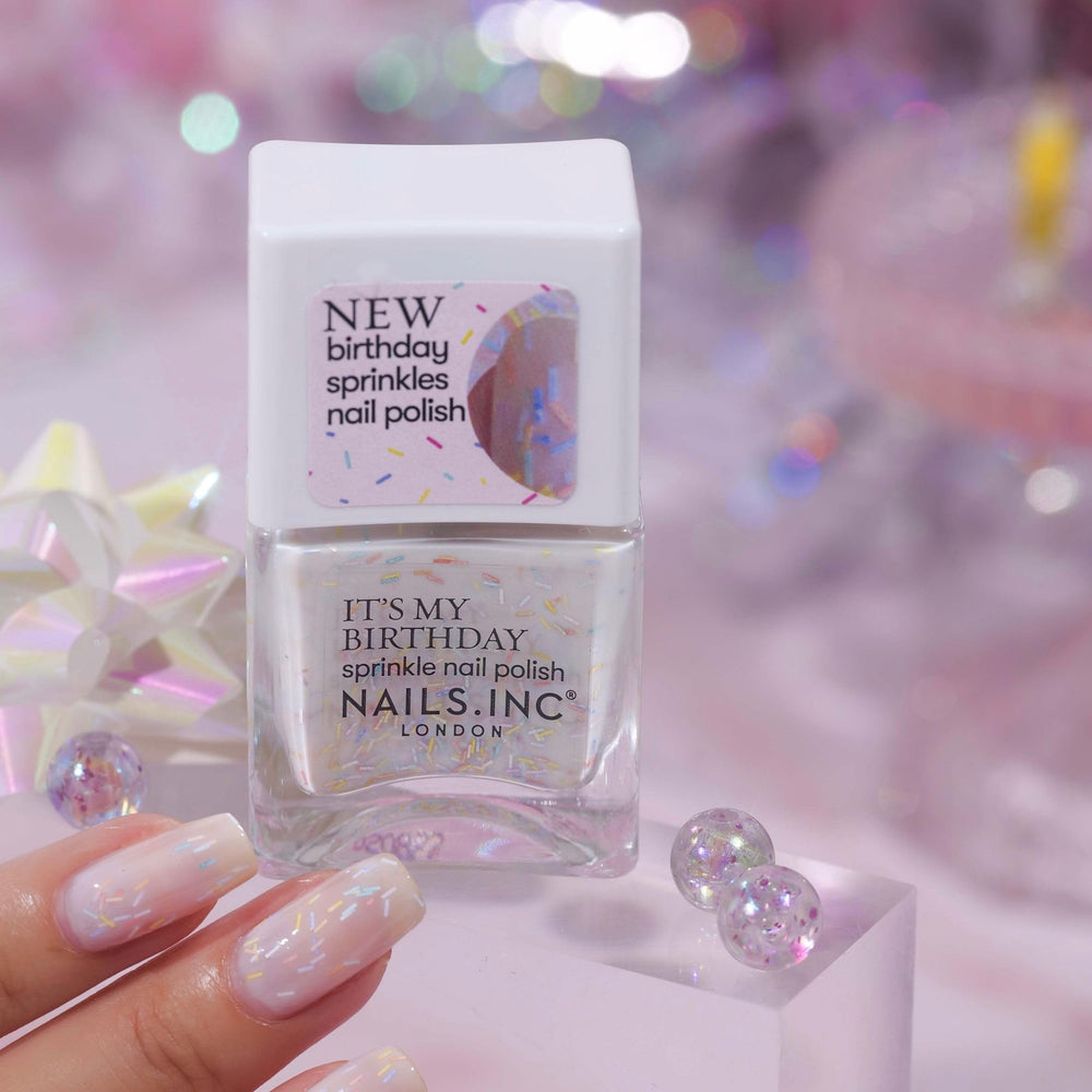 Nails Inc polish bottle next to coin showing size and travel portability