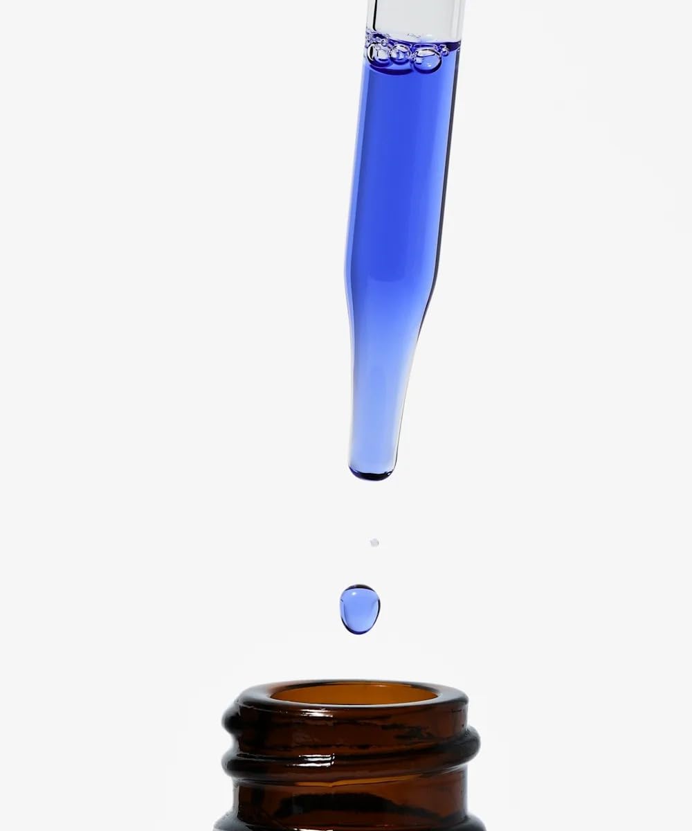 Hand applying NIOD copper serum to face, illustrating easy layering and daily use