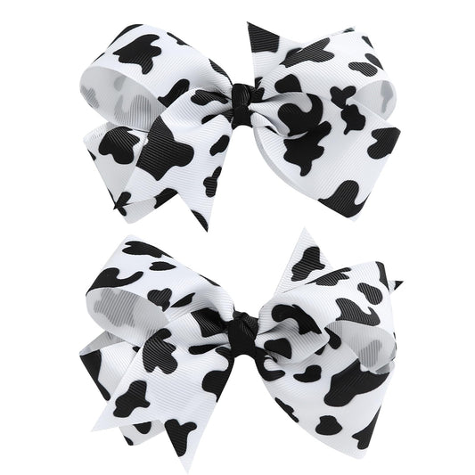 Nuolich front view of two cow print bows showing pattern and size benefits