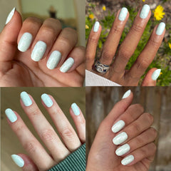 Olive & June press-on nails worn on hand displaying bold teal chrome manicure