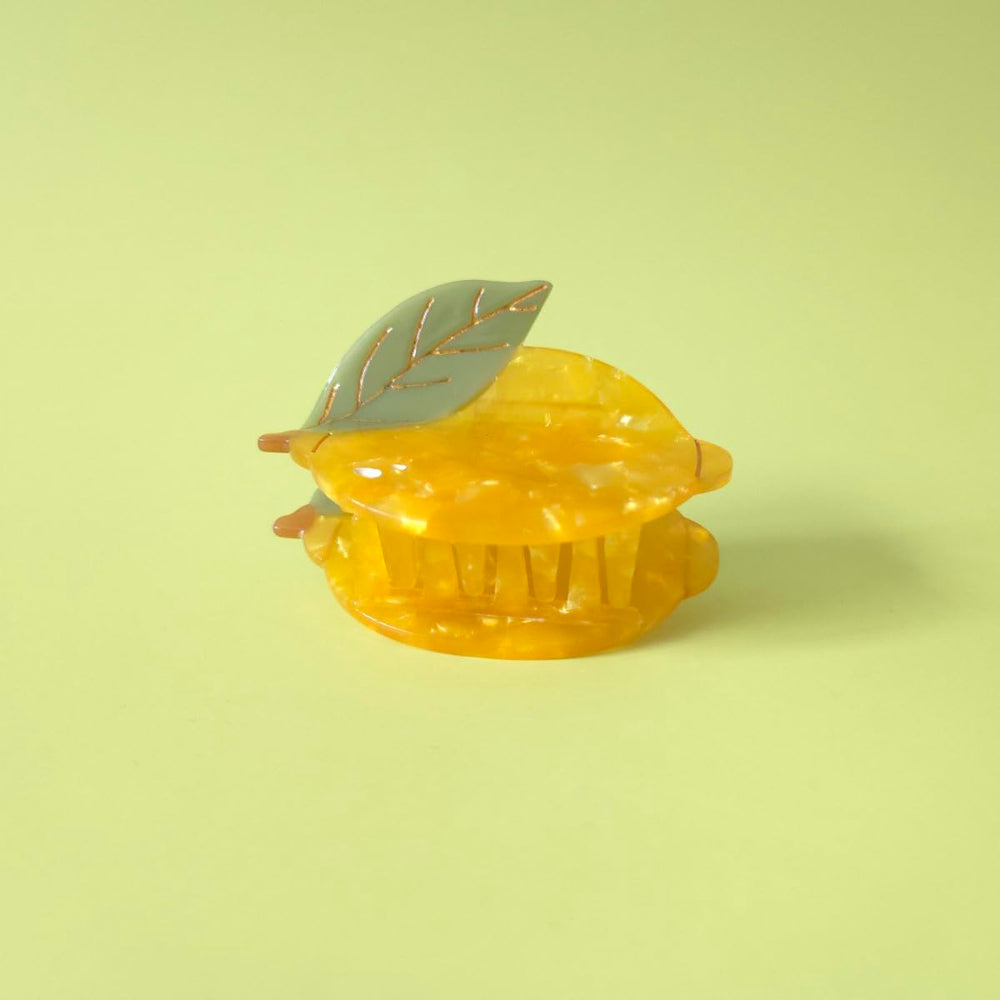 OMG Decor lemon claw clip next to a coin for scale showing compact, travel-friendly size