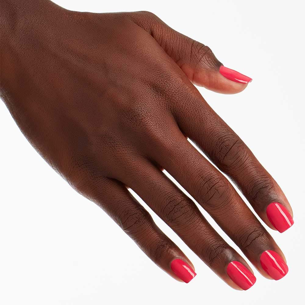 Hand holding OPI Charged Up Cherry bottle demonstrating easy application and salon look benefit