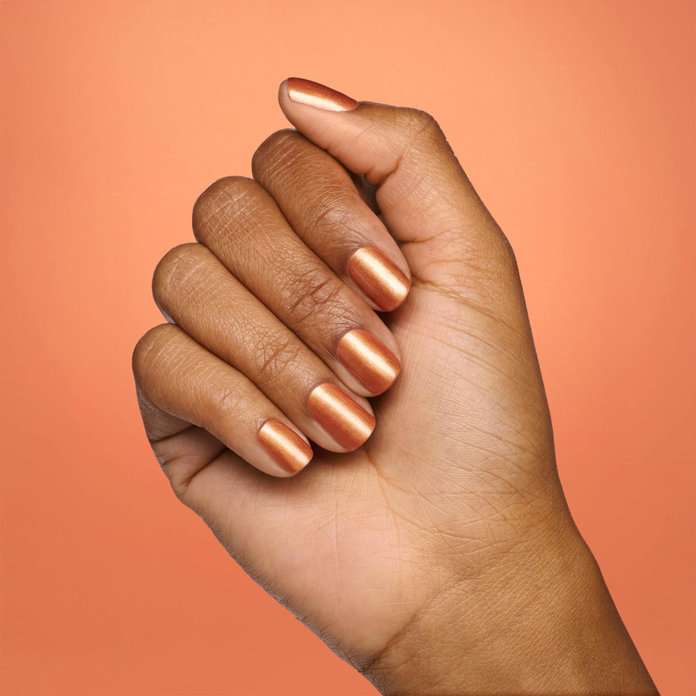 OPI bottle next to a hand for scale demonstrating compact size and travel-friendly design