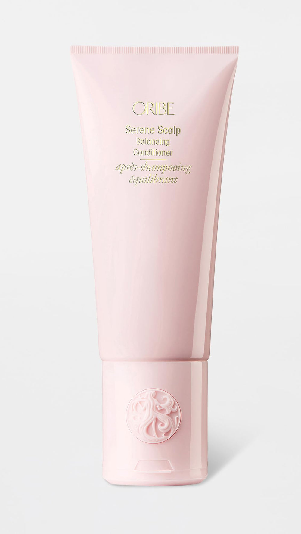 Oribe conditioner pump detail emphasizing easy dispensing and travel-friendly cap