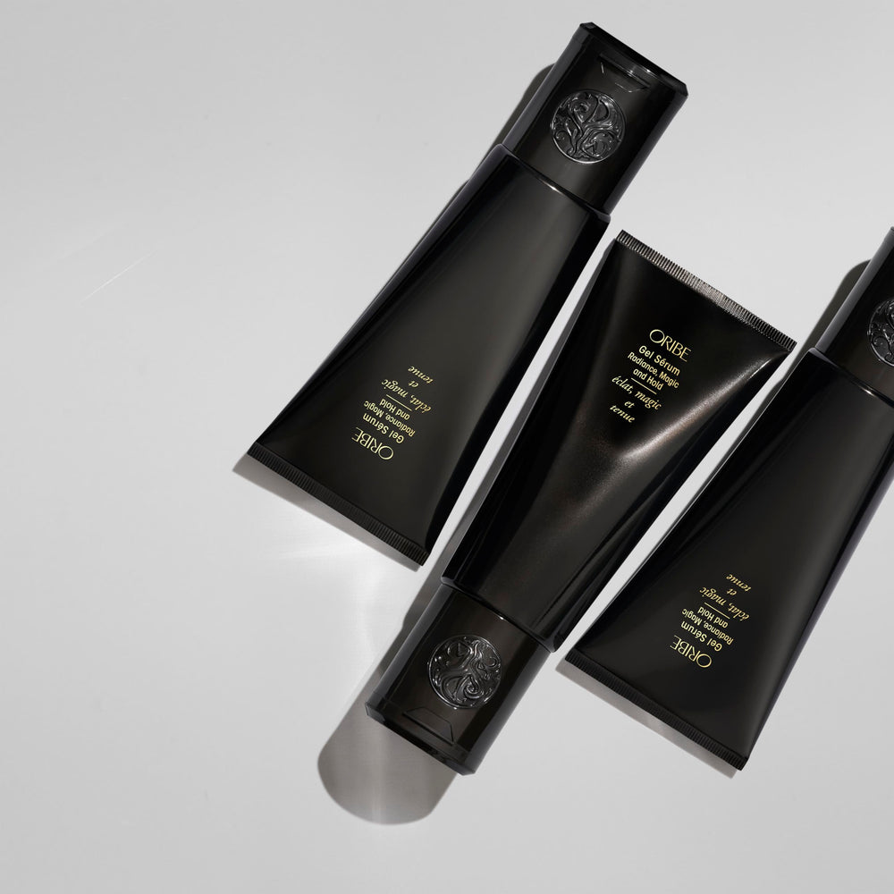 Oribe bottle in hand for size perspective and easy daily use