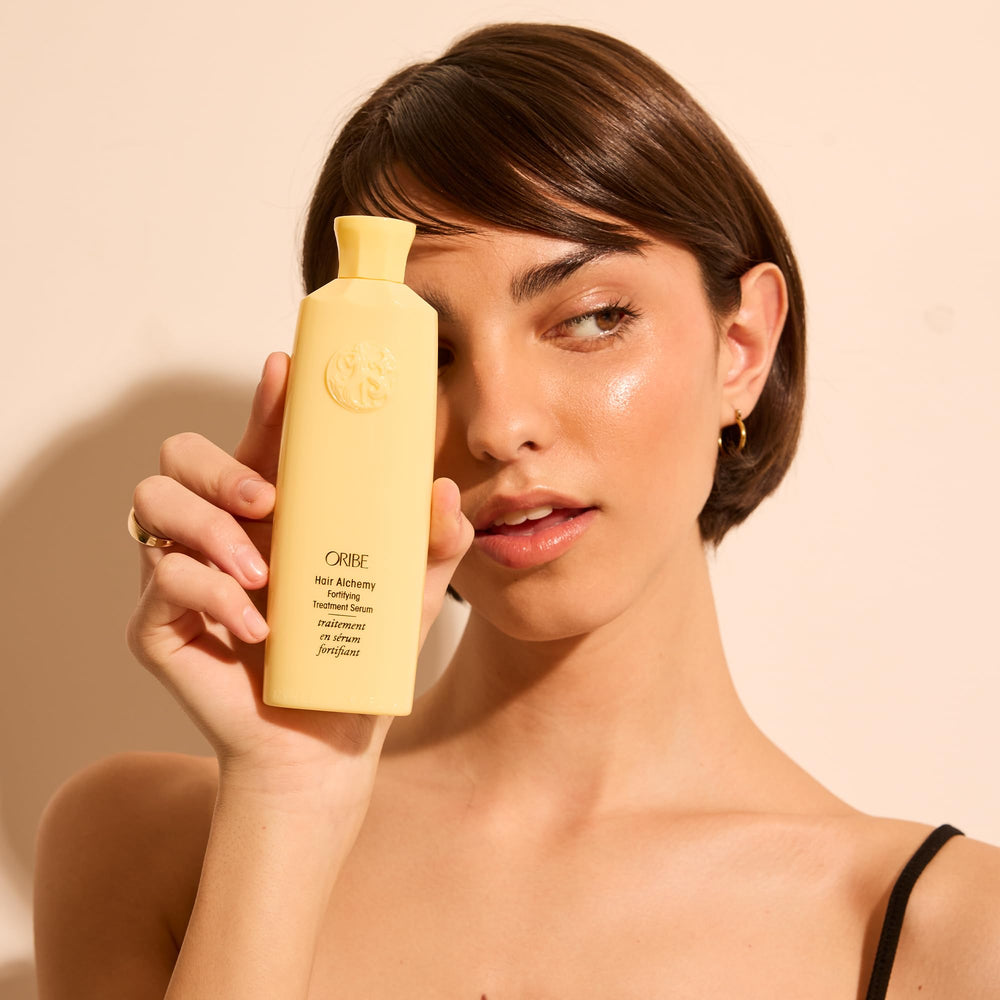 Oribe styling protection in use with flat iron showing thermal shielding advantage