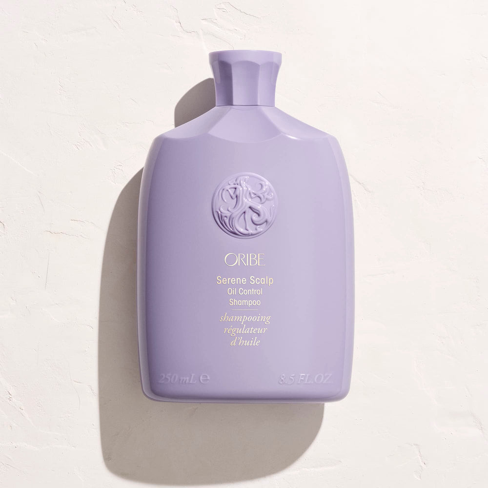 ORIBE bottle in hand during application demonstrating simple at-home use