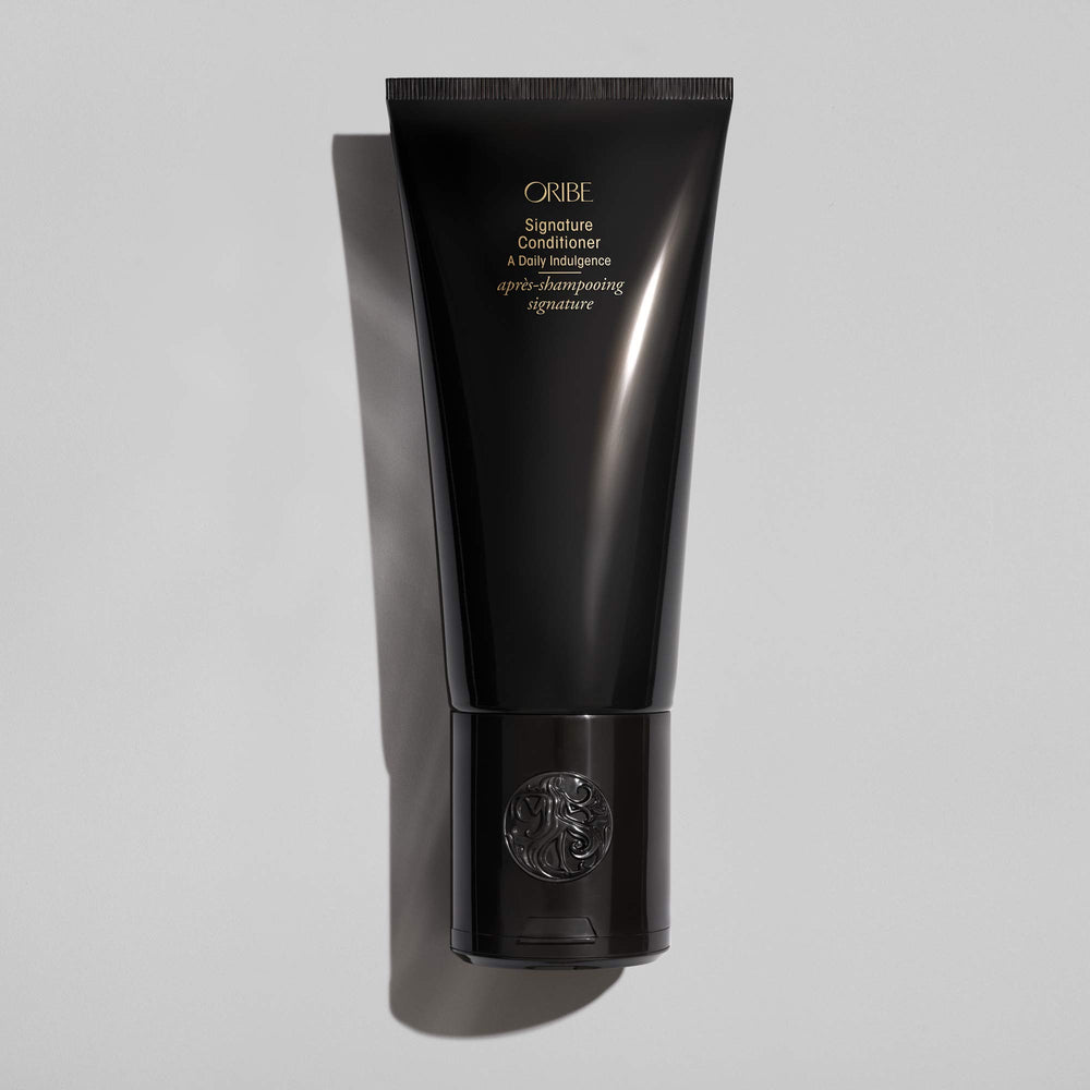 Oribe signature conditioner creamy texture shown on hand for hydrating lightweight feel