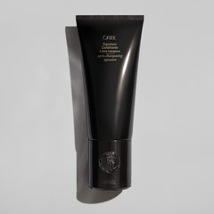 Oribe signature conditioner creamy texture shown on hand for hydrating lightweight feel