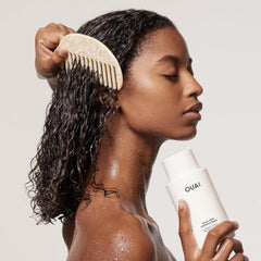 OUAI product being poured to refill a bottle for less waste