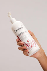 Ouidad 16 fl oz size comparison against common bottle for scale