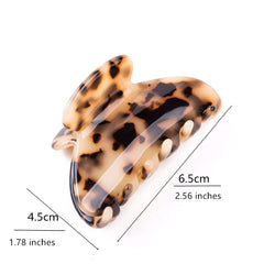 Prettyou clip next to a hand for scale showing medium size and portability
